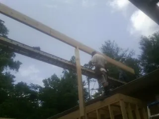 Carpenter setting a ridge beam over a new addition frame — Ice Dam Removal by Roofing Brothers in Long Eddy