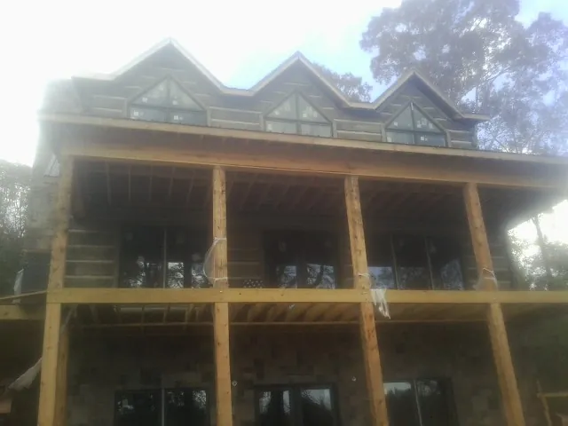 Dormers and porch framing on a large log home under construction — Roof Coating work by our crew in Long Eddy